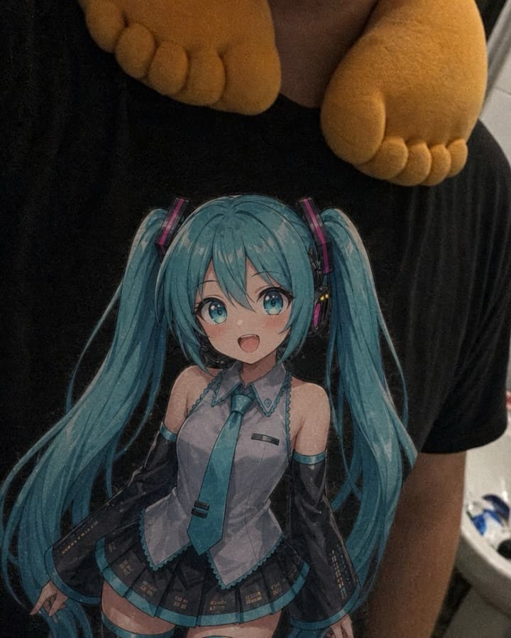 GyatFoot pillow worn around the neck over a black graphic T-shirt